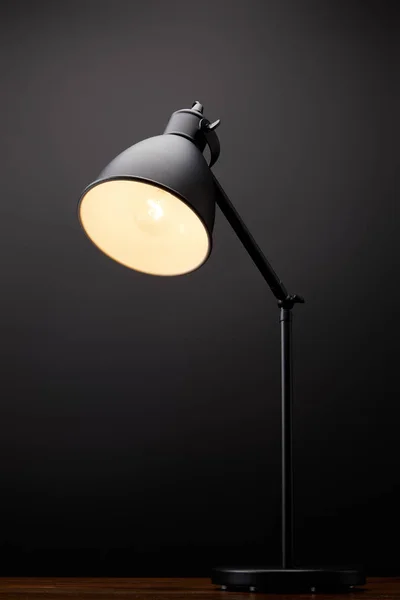 Zbliżenie Czarny Lampa Drewnianym Blatem Czarnym Tle — Zdjęcie stockowe