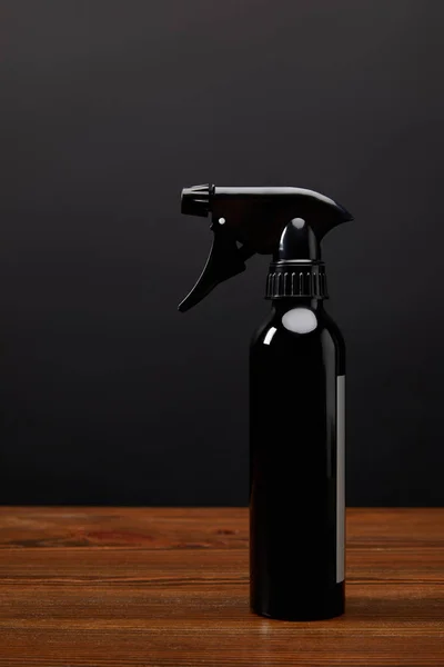 Close Van Zwarte Spray Fles Houten Oppervlak Zwarte Muur Achtergrond — Gratis stockfoto