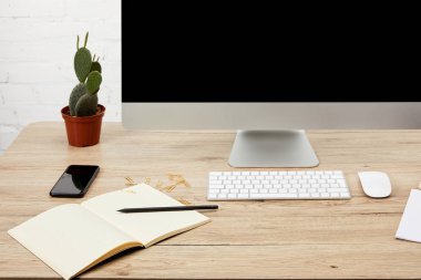 ahşap yüzeyde smartphone, notebook, bilgisayar ekran ve klavye ile tasarımcı çalışma alanı'nın görünümü kadar kapatın