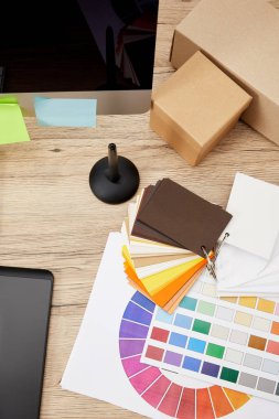 grafik tasarımcı çalışma alanı görücü usulü bilgisayar ekranı, renkli çıkartmalar, grafik tablet ve palet ile üstten görünüm ahşap yüzey üzerinde