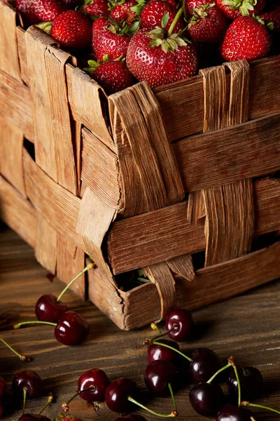 Nahaufnahme Von Kirschen Auf Holztischplatte Mit Erdbeeren Rustikalen Korb — kostenloses Stockfoto