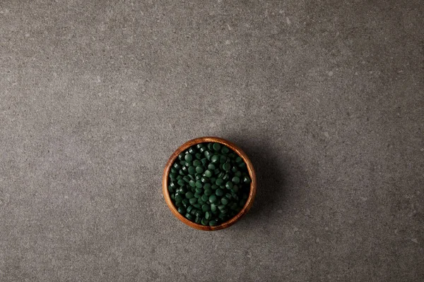 Top View Wooden Bowl Pile Spirulina Pills Stone Table — Stock Photo, Image