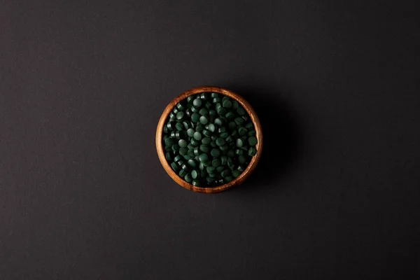 Top View Wooden Bowl Pile Spirulina Pills Grey Table — Stock Photo, Image