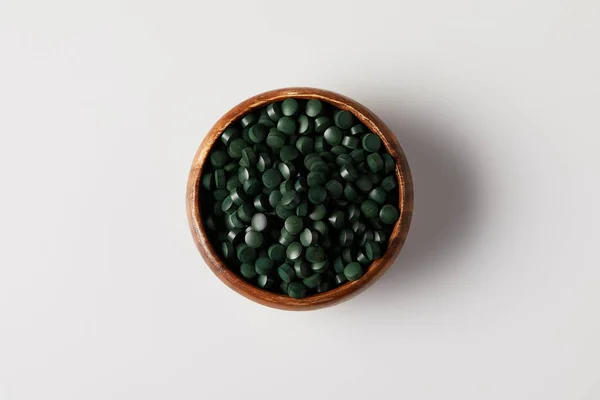 Top View Wooden Bowl Pile Spirulina Pills Grey Table — Stock Photo, Image