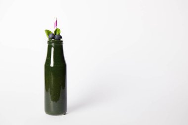 nane ile spirulina güler yüzlü şişe yaprakları, yaban mersini ve beyaz arka plan üzerinde saman içme 