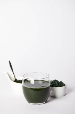 taze spirulina içki cam, kaşık, spirulina tozu ve gri arka plan üzerinde kaseler spirulina hap 