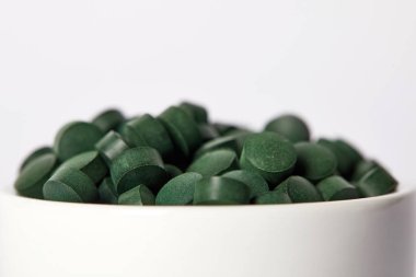 spirulina hapları üzerinde gri arka plan izole kase yığını seçici odak 