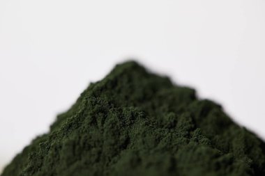 selective focus of spirulina algae powder isolated on grey background  clipart