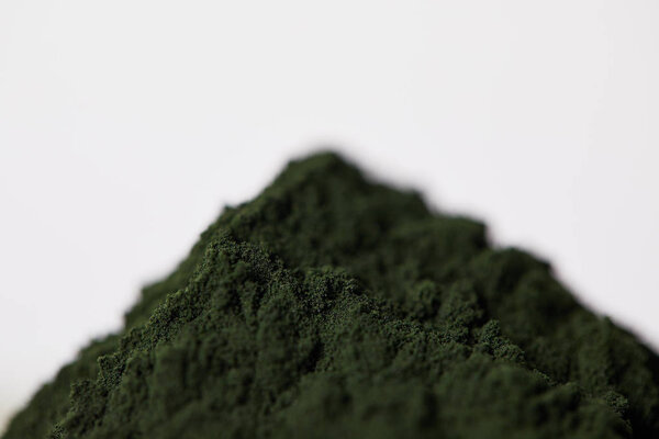 selective focus of spirulina algae powder isolated on grey background 