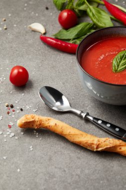sopa ve kaşık domates çorbası gri masada plakalı yakınındaki ekmek