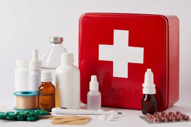 close-up shot of first aid kit box with different medical bottles and supplies on white clipart