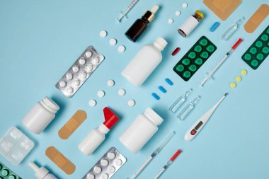 top view of various medical supplies composed in row on blue surface clipart