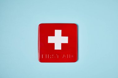 top view of red first aid kit box on blue surface clipart