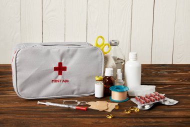 close-up shot of first aid kit with various medicines on wooden tabletop