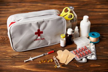 close-up shot of first aid kit with various medical supplies on wooden tabletop clipart