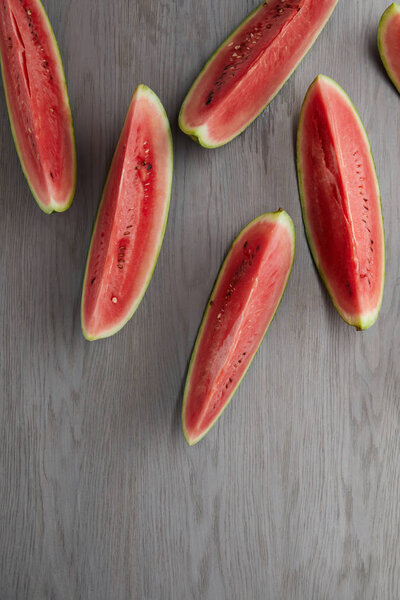 flat lay with arranged watermelon slices on grey wooden surface