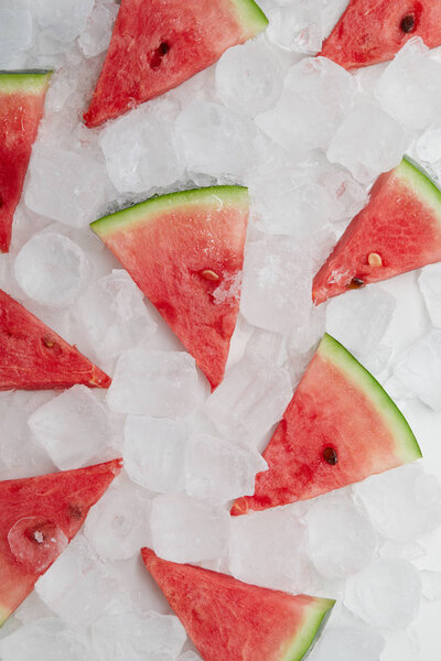 flat lay with arranged watermelon slices lying on ice cubes