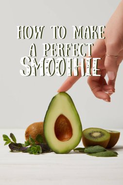 cropped view of female hand with green avocado, kiwi and mint, how to make perfect smoothie inscription clipart