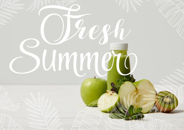 green detox smoothie with apples, kiwi and mint and on white wooden surface, fresh summer inscription