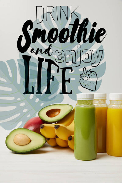 fresh detox fruits and smoothies in bottles on white background, drink smoothie and enjoy life inscription