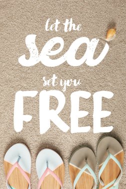 flat lay with summer flip flops and seashell on sand, let sea set you free inscription clipart