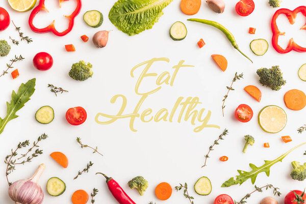 Вид сверху круга нарезанных овощей, изолированных на белом, ешьте здоровую надпись
