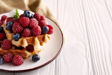 Beyaz ahşap masa üzerinde plaka üzerinde lezzetli Belçika Waffle, yakın çekim vurdu