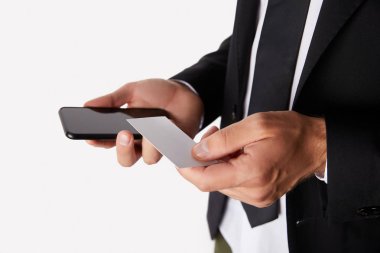 boş kartvizit ve smartphone ile boş perde beyaz arka plan üzerinde izole tutan işadamı kısmi görünümü 