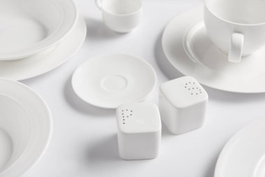 seçici odak farklı tabak, kupa, kase, saltcellar ve biber tekeri beyaz masada 