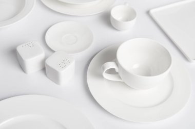 görüntü farklı tabak, kupa, kase, saltcellar ve biber tekeri beyaz masada kapatın 