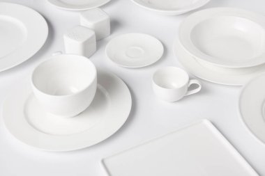 beyaz masa üzerinde farklı tabak, kase, Kupası, saltcellar ve biber tekeri görünümü kadar kapatın 