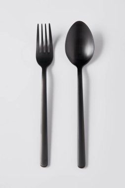 Beyaz arka plan, minimalist kavramı üzerinde siyah çatal ve kaşık üstten görünüm