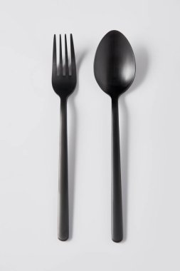 top view of black fork and spoon on white background, minimalistic concept clipart