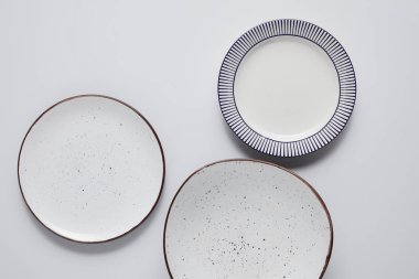 top view of three different ceramic plates on white table, minimalistic concept clipart