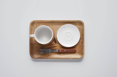 tabak, kase ve çatal ile ahşap tepsi üstten görünüm beyaz masa, minimalist kavramı üzerinde