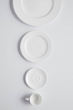 Çeşitli tabak ve bardak beyaz masa, minimalist kavramı satırındaki üst düzenlenmiş