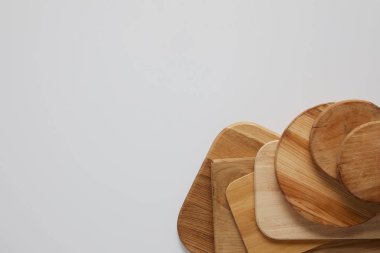 top view of stack of different wooden cutting boards on white table clipart