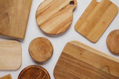 top view of various wooden cutting boards on white table clipart