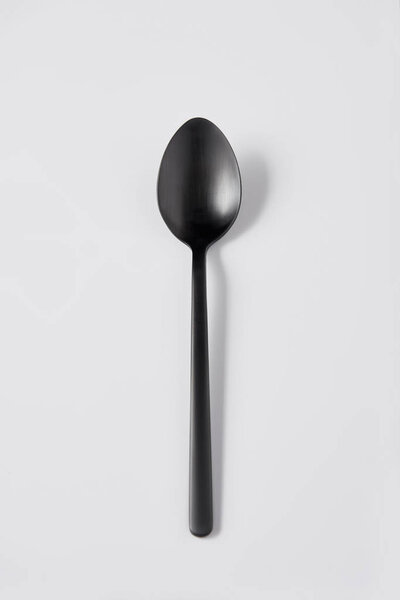 elevated view of black spoon on white background, minimalistic concept