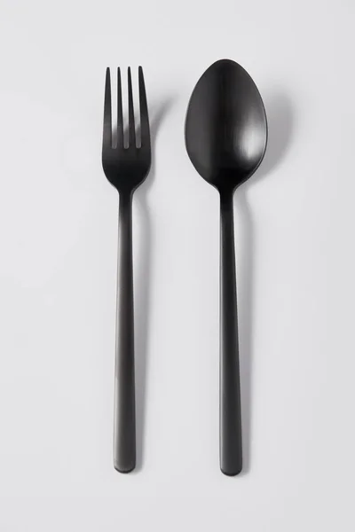 黑色叉子和勺子的顶部视图白色背景 简约概念 — 图库照片