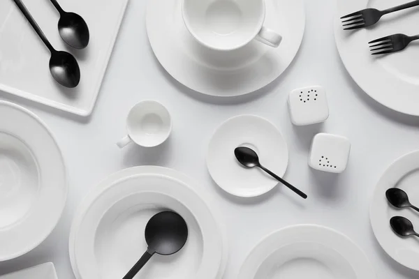 Beyaz Masa Üzerinde Siyah Kaşık Çatal Salata Kaşığı Farklı Tabak — Stok fotoğraf