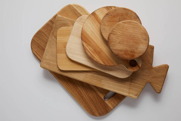 top view of stack of different wooden cutting boards on white table