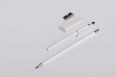 kalem, silgi ve beyaz yüzey satırındaki mockup için düzenlenmiş kalemtıraş kalem yakın çekim vurdu