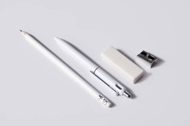 close-up shot of pen with pencil, eraser and sharpener in row on white surface for mockup clipart