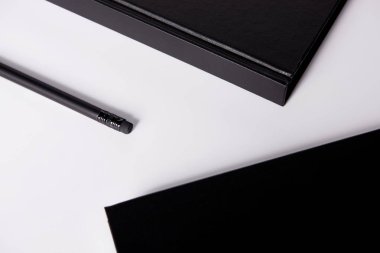 yakın çekim siyah Notebook mockup için beyaz yüzeyi kalem ile vurdu