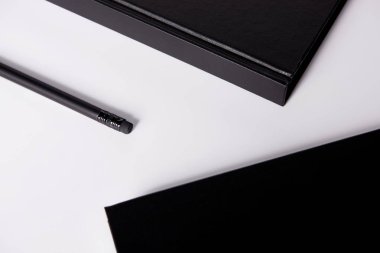 close-up shot of black notebooks with pencil on white surface for mockup clipart