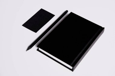 isometric view of black notebook with pencil and business card on white surface for mockup clipart