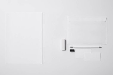 mockup için beyaz yüzeyinde çeşitli nesneleri kağıt ve silgi ve kalemtıraş kalem üstten görünüm