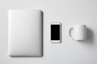 laptop ile smartphone ve Kupası üstten görünüm mockup için beyaz masa üzerinde