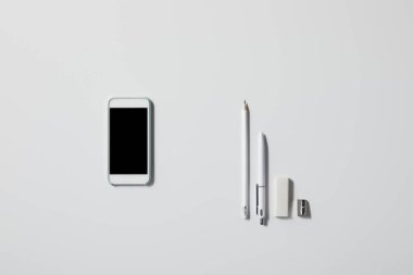 smartphone satırdaki çeşitli malzemeleri ile üstten görünüm mockup için beyaz masa üzerinde